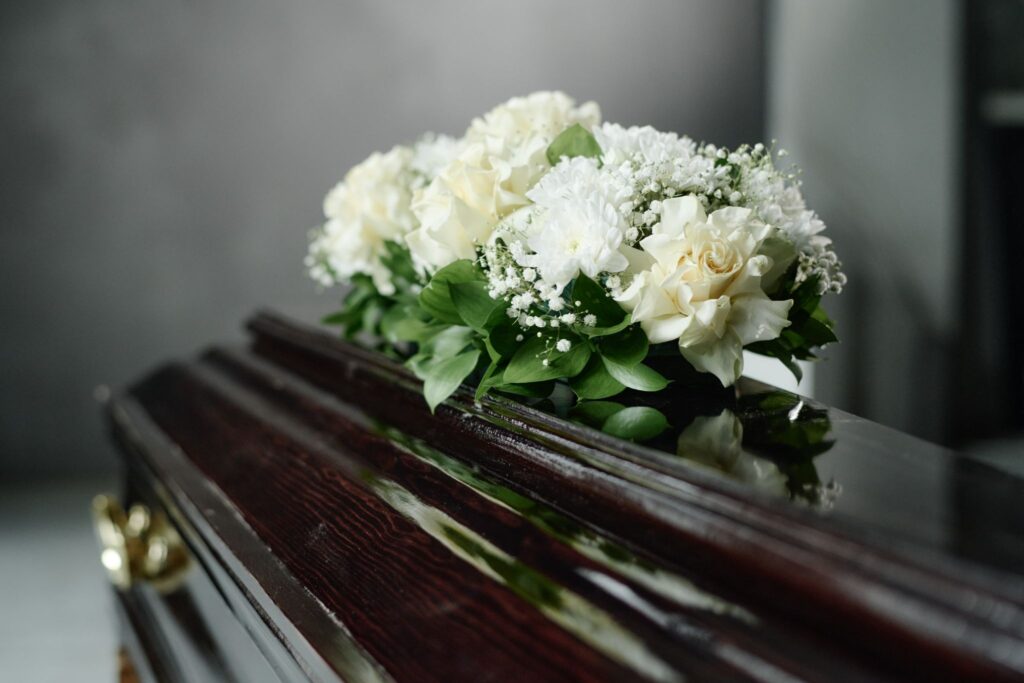 a coffin with white flowers put on top of it