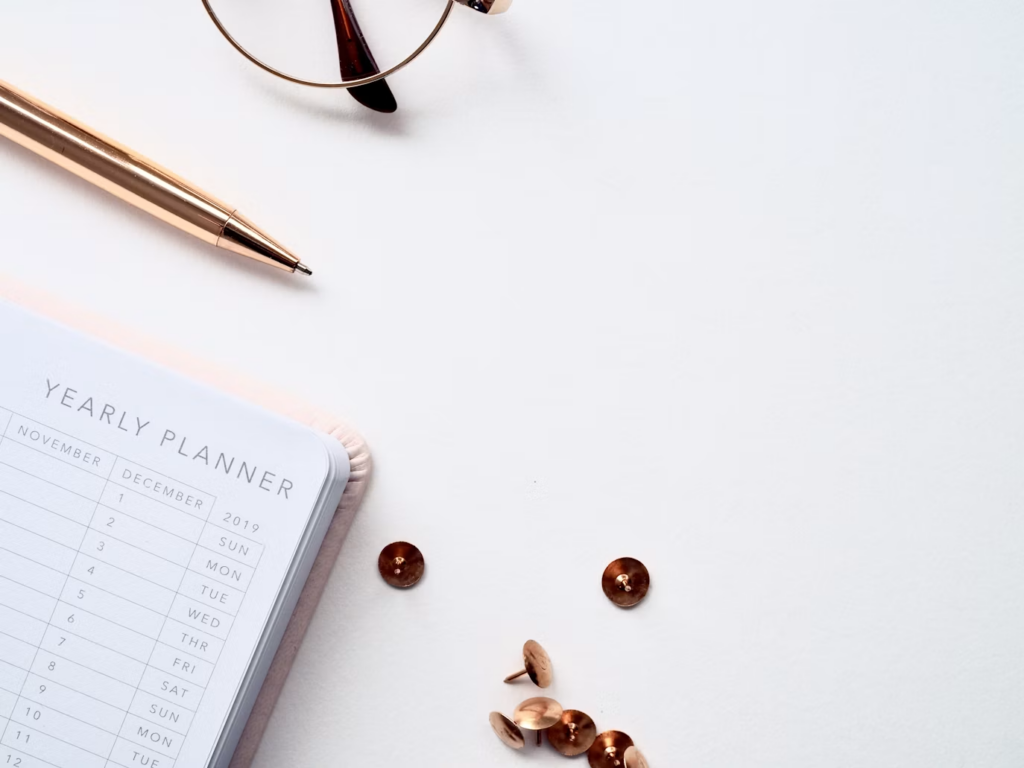 Notebook, glasses and pen on the table.
