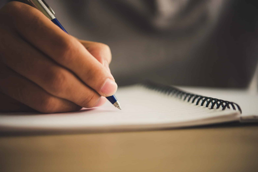 Man writing something on a notebook.